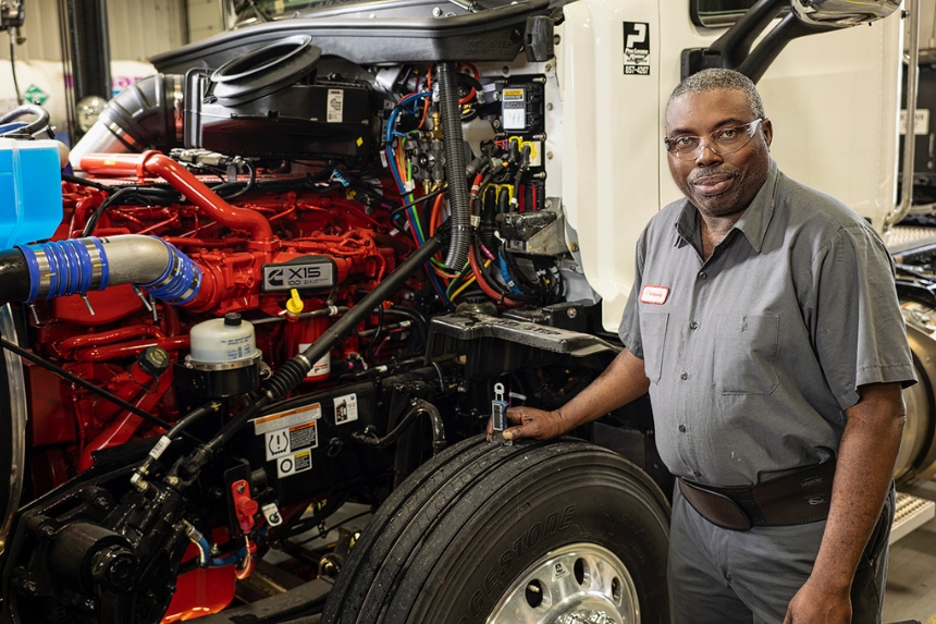 Technician standing next to truck wheel